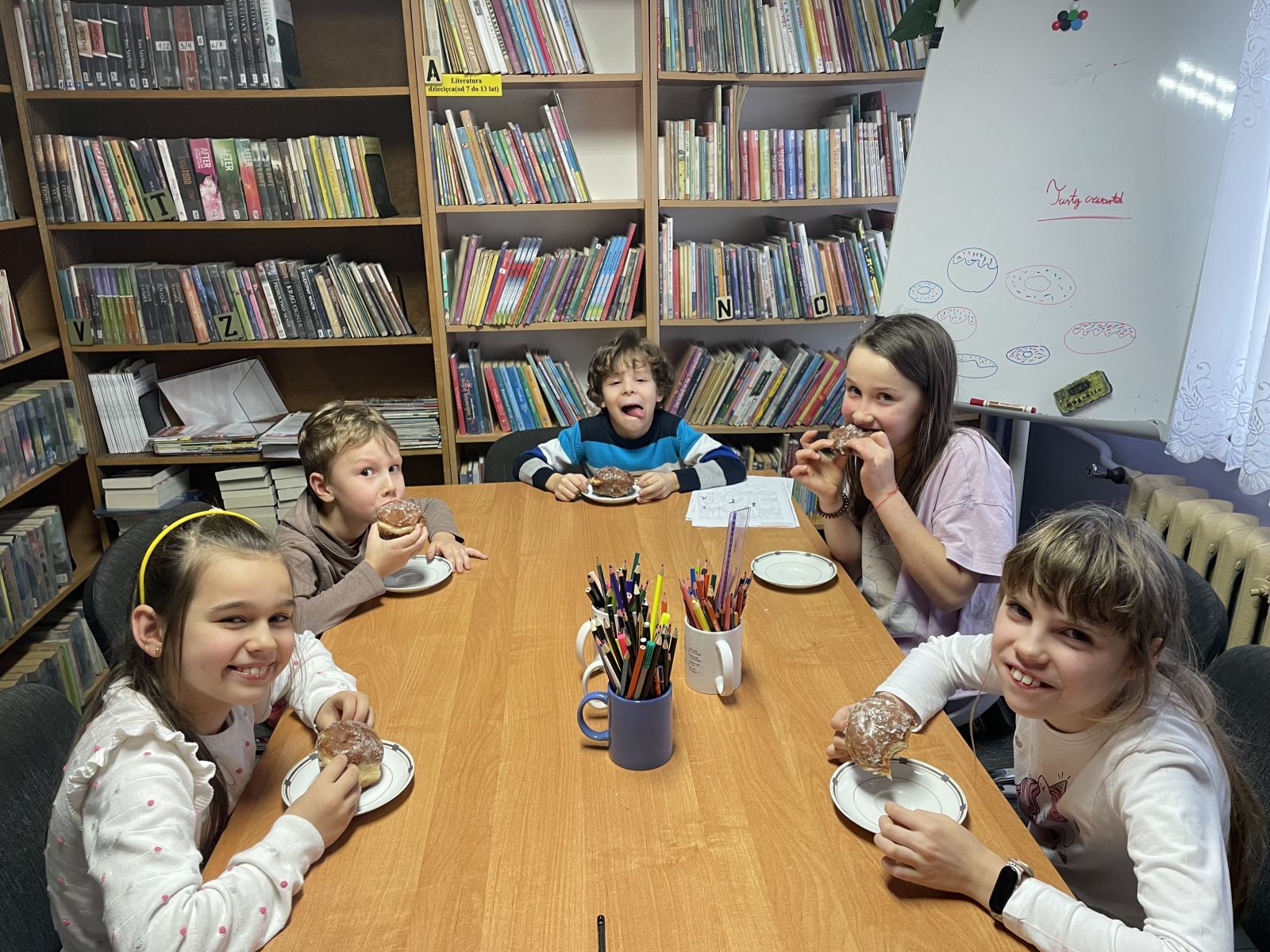 Dzieci jedzące pączki podczas zajeć w Klubie Mola.