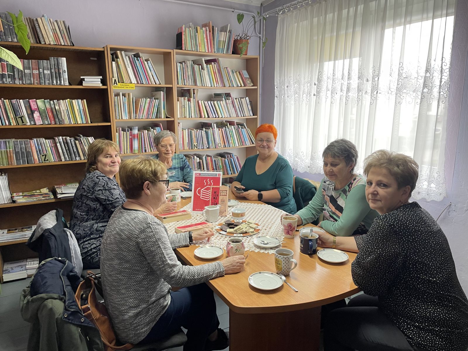 Zdjęcie przedstawia uczestników spotkania w bibliotece.
